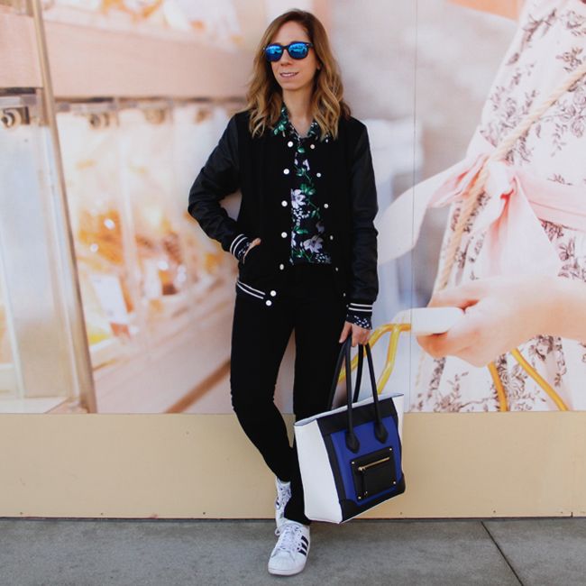 Fashion blogger The Key To Chic wears an Equipment floral silk blouse, J Brand skinny jeans in black, Mossimo colorblock handbag, and Adidas superstar 2 sneakers.