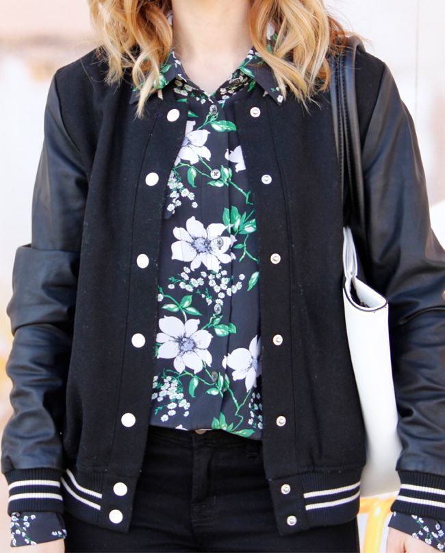 Fashion blogger The Key To Chic wears an Equipment floral silk blouse, Forever 21 varsity jacket with faux leather sleeves, and J Brand skinny jeans in black