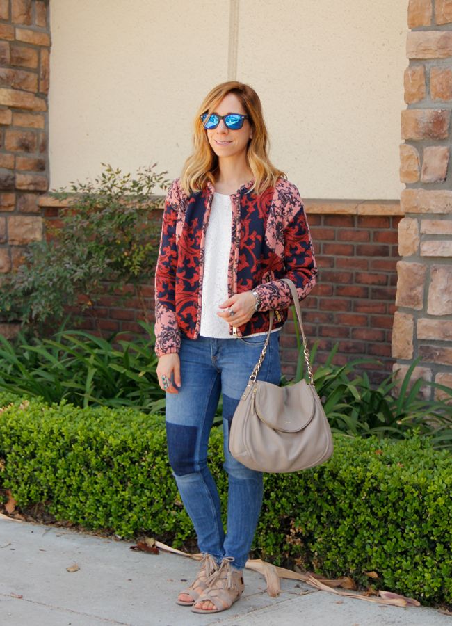Fashion blogger The Key To Chic wears a quilted H&M bomber jacket with patchwork skinny jeans, Kate Spade Little Penny bag, and Sam & Libby 'Arianna' sandals
