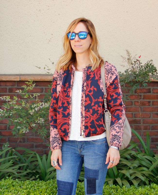 Fashion blogger The Key To Chic wears a quilted H&M bomber jacket with patchwork skinny jeans, Kate Spade Little Penny bag, and Sam & Libby 'Arianna' sandals