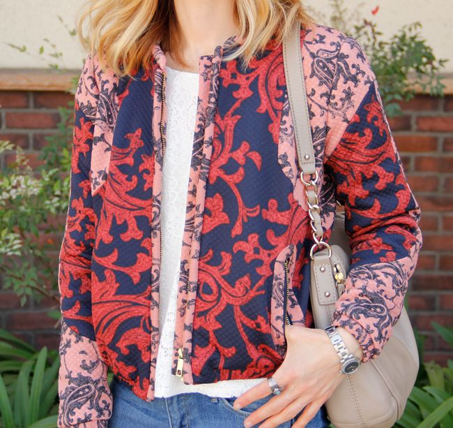 Fashion blogger The Key To Chic wears a quilted H&M bomber jacket with patchwork skinny jeans, Kate Spade Little Penny bag, and Sam & Libby 'Arianna' sandals