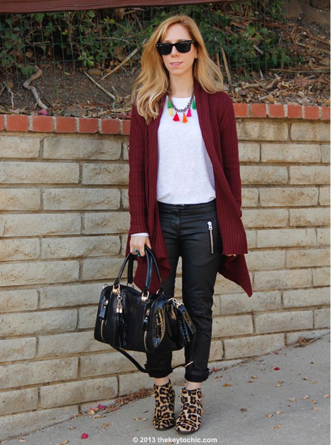 L.A. fashion blogger The Key To Chic wears an Isabel Marant for H&M white T-shirt and black waxed biker jeans with a Mellow World handbag, Charlotte Russe oxblood waterfall cardigan, and Topshop leopard boots