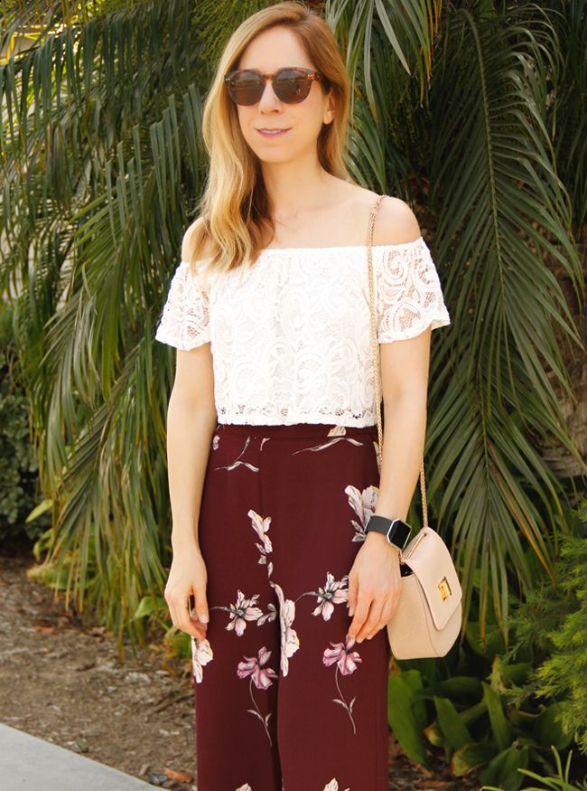 Los Angeles fashion blogger The Key To Chic wears an off the shoulder lace blouse, LC Lauren Conrad floral flare pants, and Who What Wear Collection crossbody saddle bag